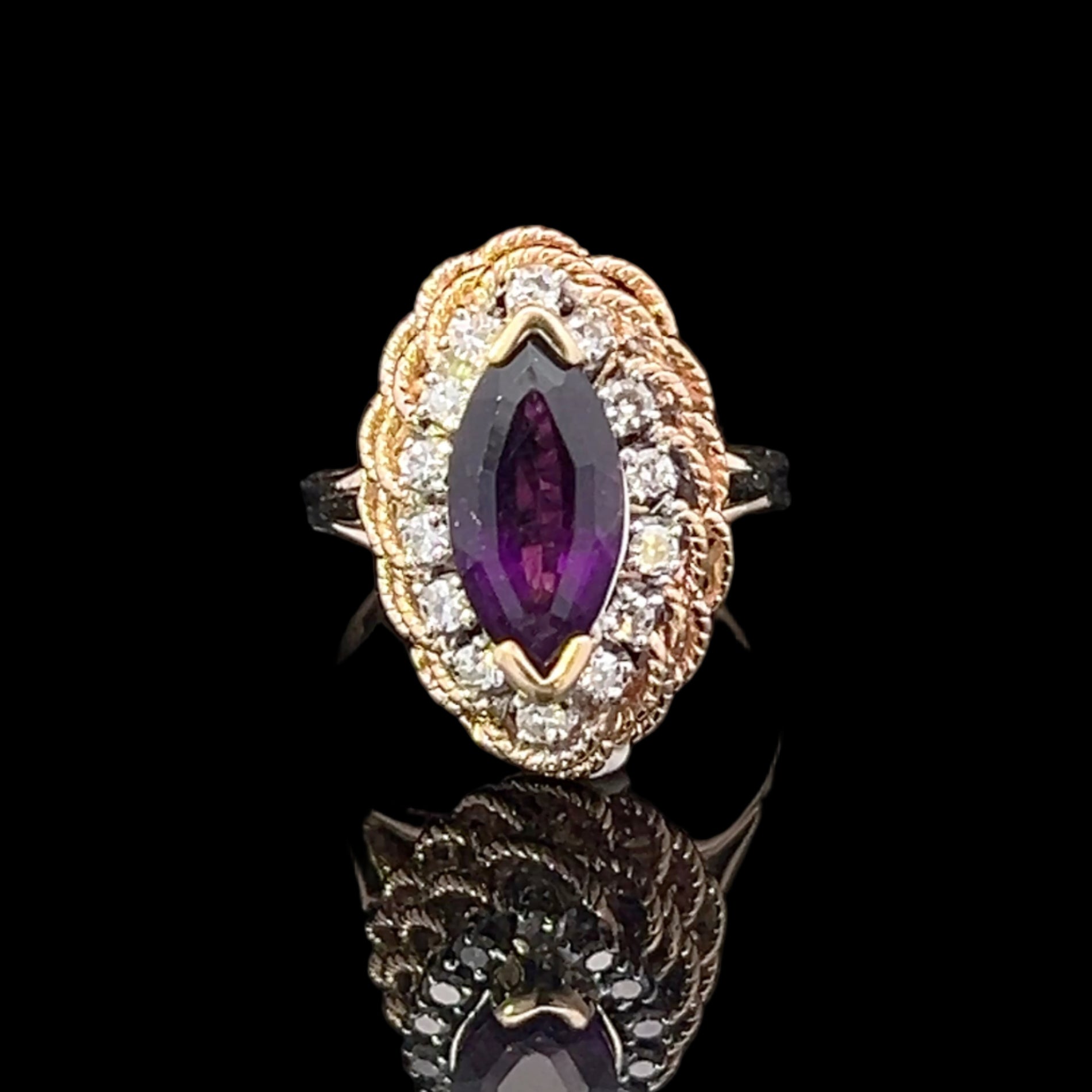 Gold ring with a marquise-shaped purple gemstone on a black background