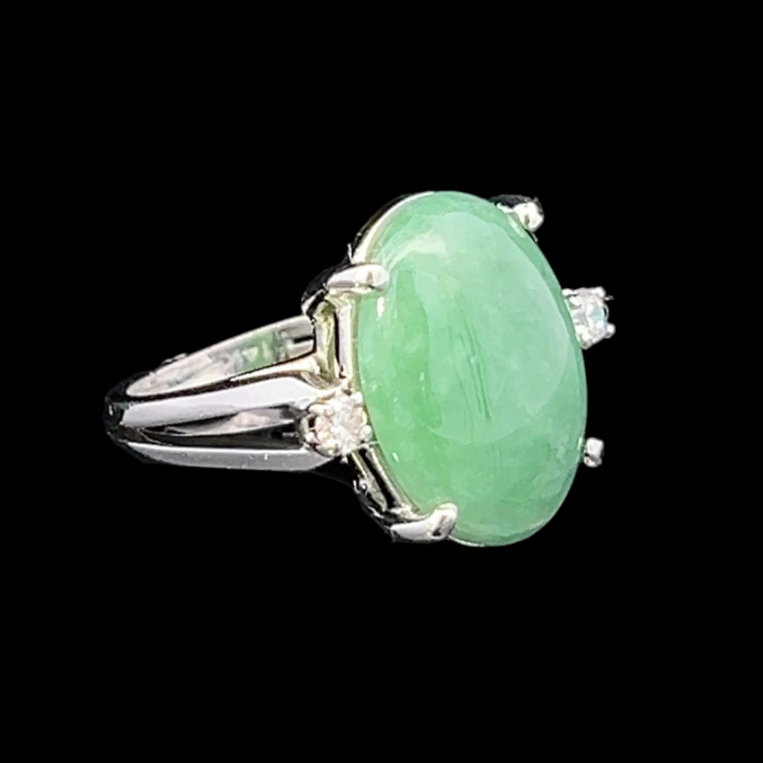 Green jade ring with silver setting on a black background