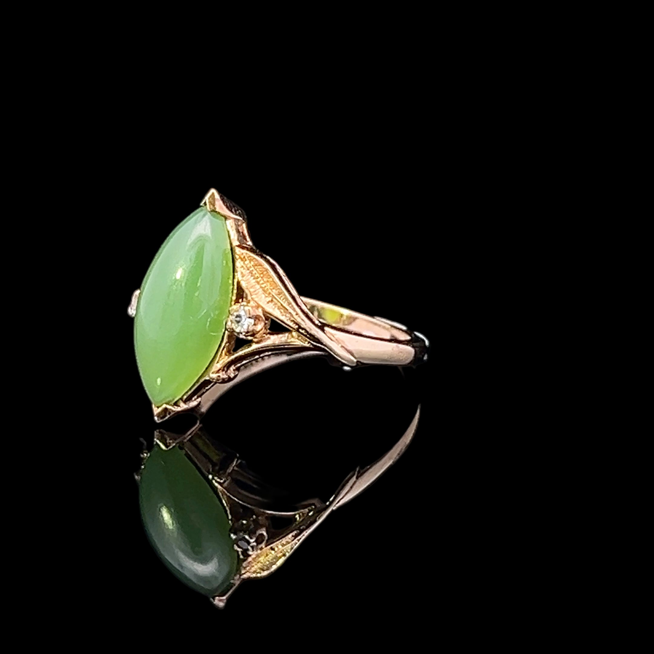 Gold ring with a green gemstone on a black background