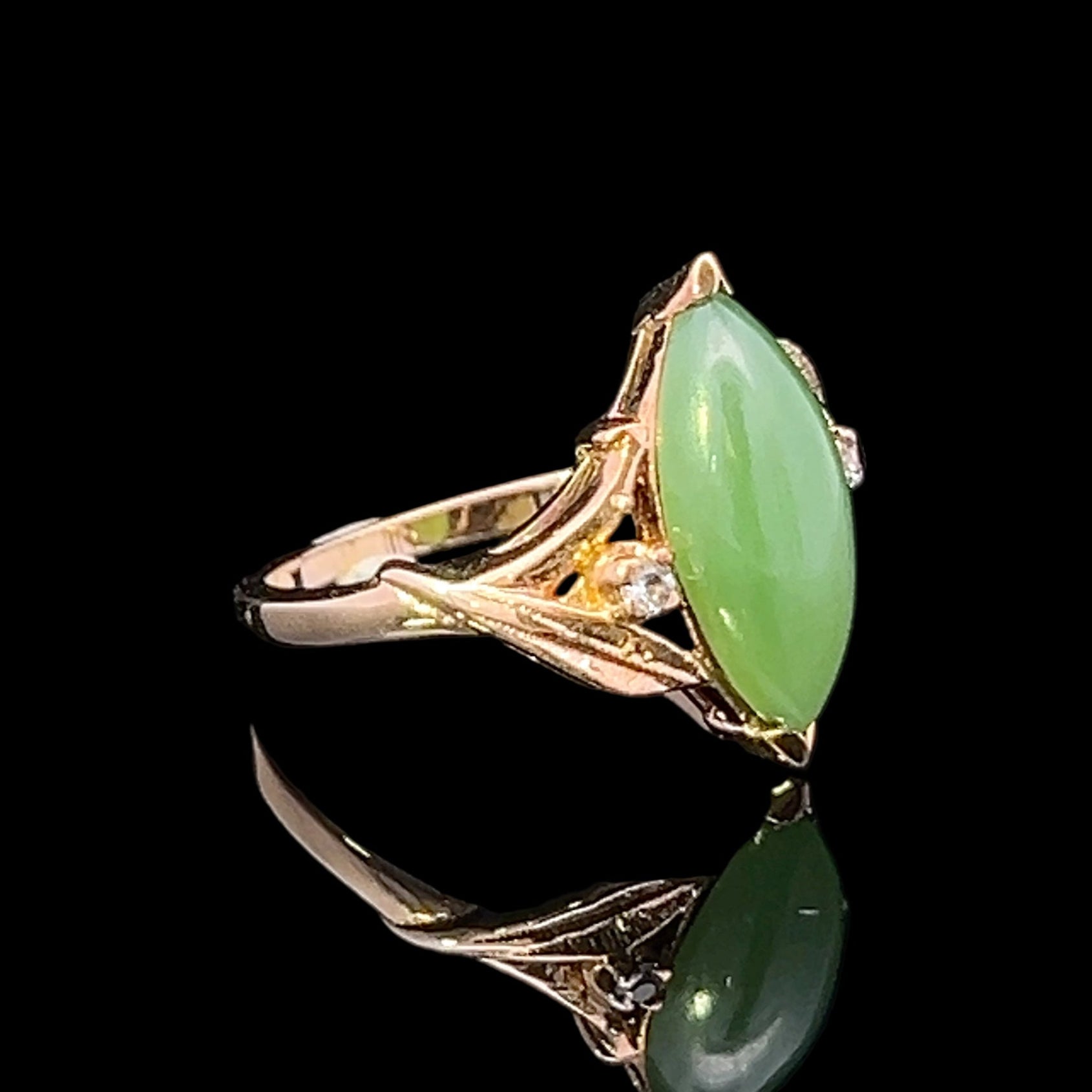 Gold ring with green gemstones on a black background