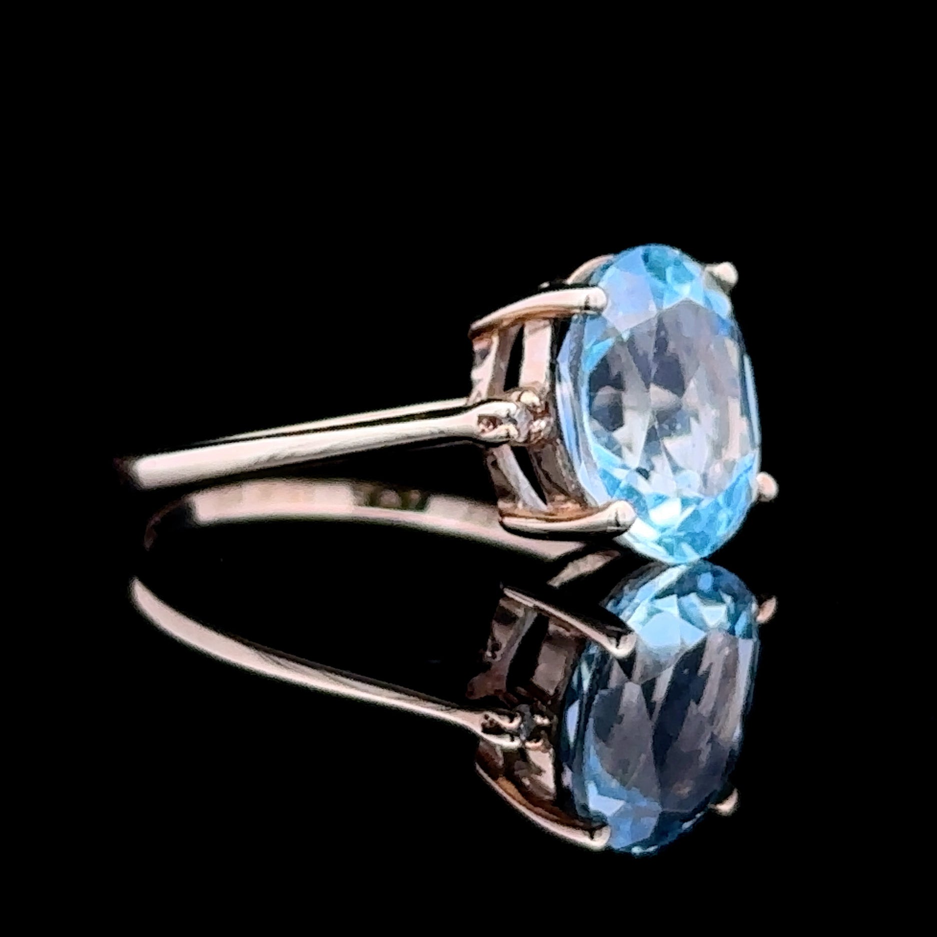 yellow gold ring with oval blue topaz and diamonds
