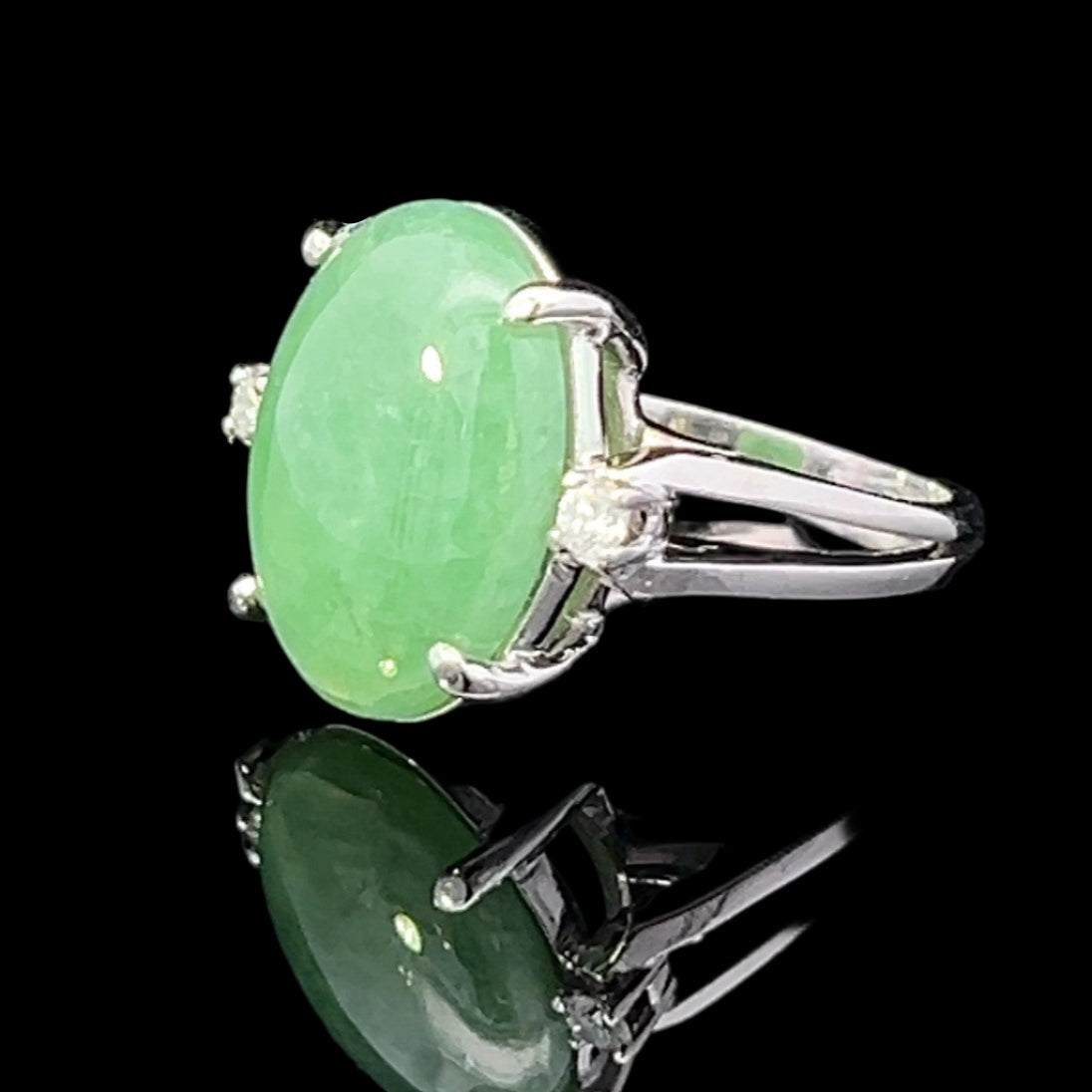 Green jade ring with silver setting on a black background