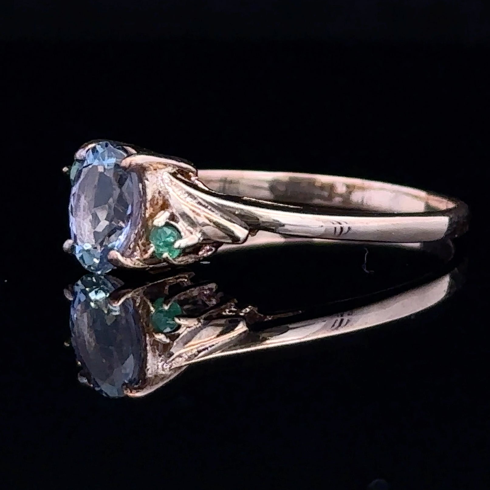 Yellow gold ring with blue sapphire and green emerald accents
