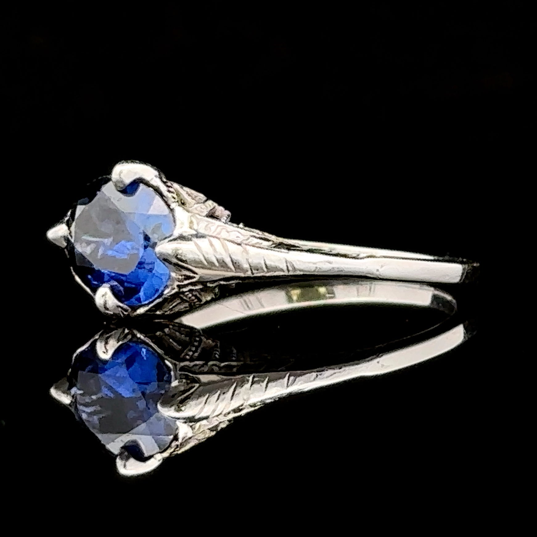 White gold ring with filigree and blue sapphire
