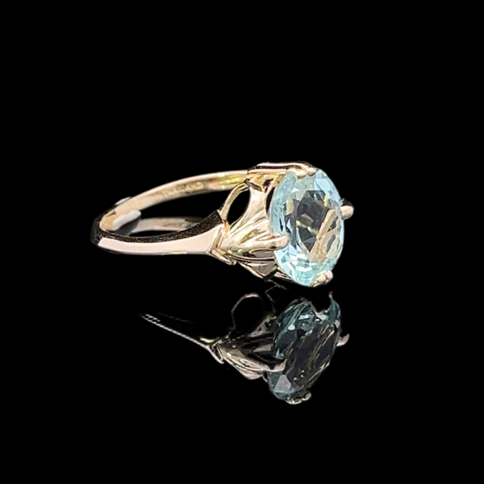 Gold ring with a blue gemstone on a black background